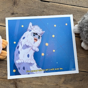 Puede incluir: Una impresión que presenta una criatura parecida a un Furby de dibujos animados sobre un fondo azul con estrellas amarillas. La criatura es blanca con manchas azules y una expresión preocupada. El texto en la impresión dice: "Tengo miedo de que esto sea todo lo que seré".