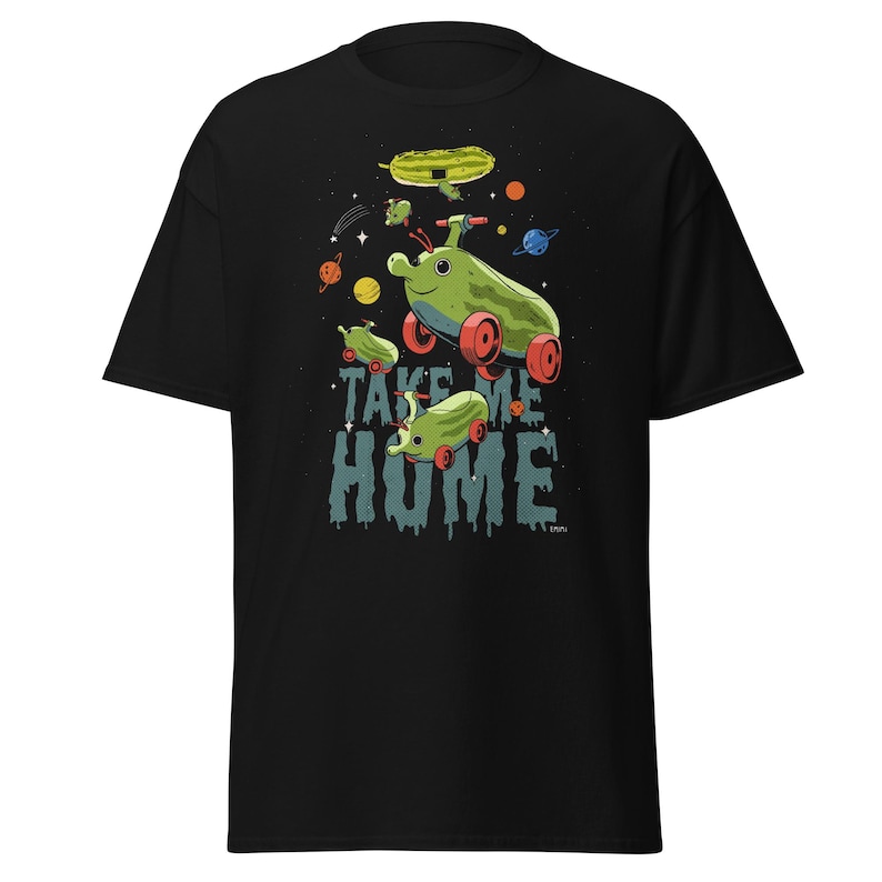 Peut inclure: T-shirt noir avec un motif fantaisiste de v&eacute;hicules verts en forme de concombre avec des roues rouges, sur fond spatial. L'inscription "TAKE ME HOME" est imprim&eacute;e en dessous. Des plan&egrave;tes et des &eacute;toiles sont &eacute;galement visibles.
