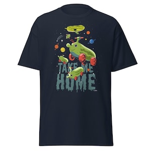 Peut inclure: T-shirt bleu marine avec un motif fantaisiste de v&eacute;hicules verts en forme de concombre avec des roues rouges, sur fond &eacute;toil&eacute;. Le texte "TAKE ME HOME" est affich&eacute; en dessous. Un design amusant et ludique.