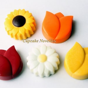 May include: Five chocolate flower decorations, including a yellow sunflower, a white daisy, and three tulips in red, orange, and yellow.