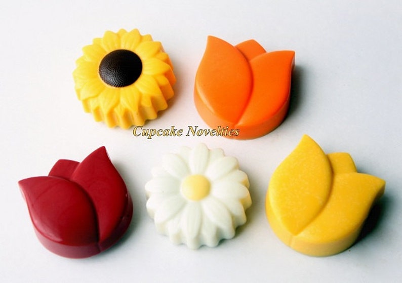 May include: Five chocolate flower decorations, including a yellow sunflower, a white daisy, and three tulips in red, orange, and yellow.