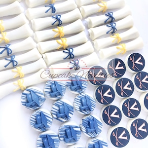 May include: A collection of graduation-themed treats, including white chocolate diplomas tied with blue and yellow ribbons, and round chocolate cookies decorated with blue graduation caps and white chocolate drizzle.