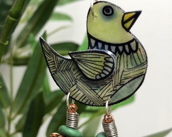May include: Green and white bird-shaped dangle earring with green beads and copper wire accents.