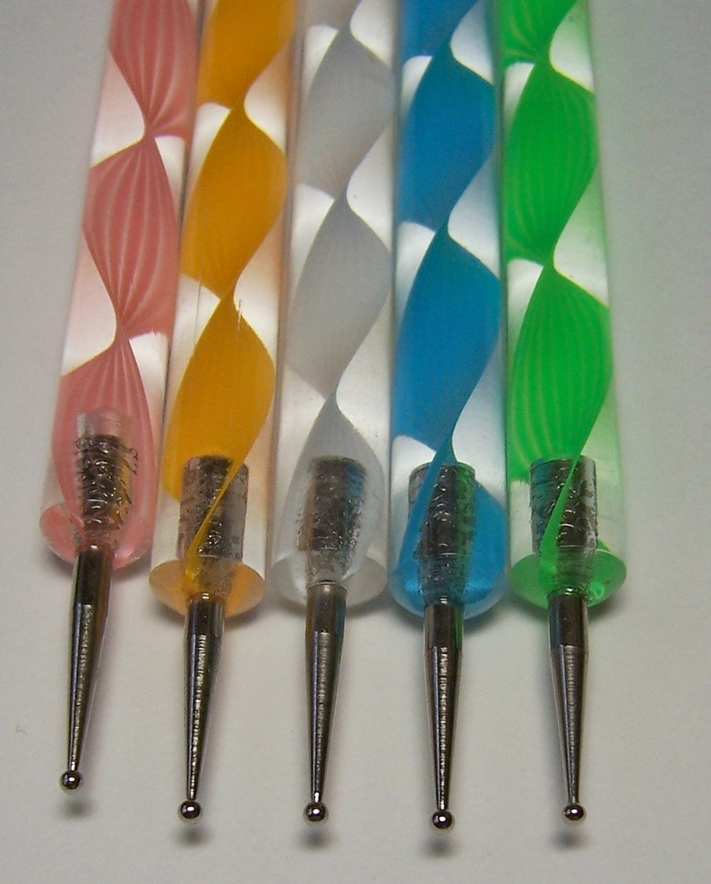Pu&ograve; includere: Cinque strumenti per punteggiare con manici di diversi colori. I manici sono rosa, giallo, bianco, blu e verde. Ogni manico ha un motivo a spirale bianco. Gli strumenti hanno punte in metallo argentato.