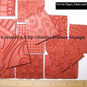 May include: A set of 10 red rubber stamps with various patterns, including swirls, dots, and geometric shapes. The stamps are labelled "Creative Art by Obertin Texture Stamps" and "Use for Paper, Fabric and Clay".