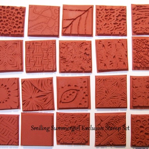May include: A set of 16 red rubber stamps with various patterns, including geometric, floral, and abstract designs. The stamps are arranged in a grid on a white background. The text "Smiling Summergirl Exclusive Stamp Set" is printed below the stamps.