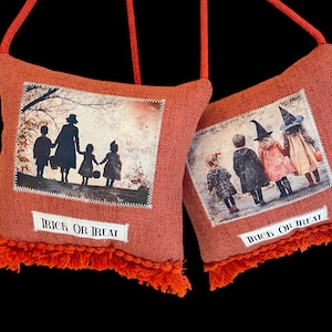 May include: Two orange fabric bags with a vintage Halloween theme. Each bag features a sepia-toned image of children and the text "TRICK OR TREAT". The bags have orange fringe and red straps.