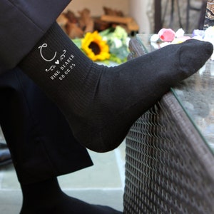 May include: Black socks with white embroidered text that reads "Ring Bearer 08.06.25" and a stylized letter "C" with a heart.