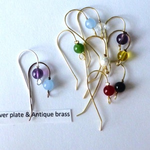 May include: A set of earring hooks with various colored beads. The hooks are made of antique brass and silver plate. The beads are blue, green, purple, white, red, yellow, and black.