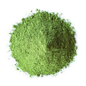 May include: A pile of finely ground, vibrant green powder against a stark white background. The powder appears to be matcha or a similar finely milled green tea, with a slightly textured appearance.