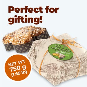 Op de afbeelding: Een ingepakt cadeau met een label en een gebakken brood. Het cadeau is verpakt in papier met een stadsgezichtontwerp en vastgebonden met oranje touw. Op het label staat "Bio Vergani". Het brood is bedekt met hagelslag en chocoladeschilfers. Nettogewicht 750 g.