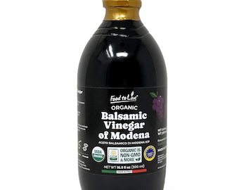 May include: A dark glass bottle of organic balsamic vinegar of Modena. The label reads "Food to Live" and "Organic Balsamic Vinegar of Modena." The bottle has a gold-colored cap and contains 16.9 fl oz (500 ml) of vinegar.