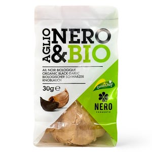 May include: A package of organic black garlic, labeled "Nero & Bio." The package features a green and white design with the text "Ail Noir Biologique, Organic Black Garlic, Biologischer Schwarzer Knoblauch." The package contains 30g of garlic.
