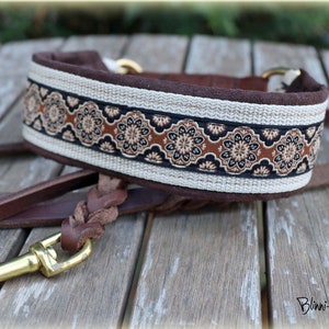 Pode incluir: Uma trela de cão de couro castanho com uma pega de couro trançada e um clipe de metal dourado. A trela está presa a uma coleira de cão castanho e bege com uma faixa de tecido estampada.