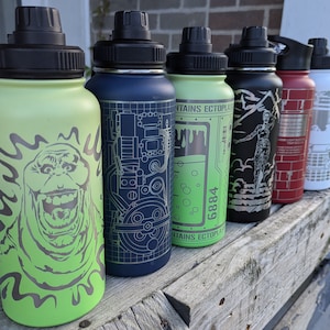May include: Five stainless steel water bottles with different designs. The bottles are green, blue, green, black, red, and white. The designs include a ghost, a blueprint, a ghost, a woman, a brick wall, and a building. The bottles have black lids.