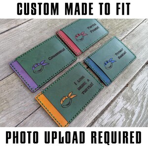 May include: Four custom-made leather cardholders with Teenage Mutant Ninja Turtles designs. Each cardholder is green with a different colored accent and a turtle graphic. Text includes "Cowabunga!", "Turtle Power!", "I love being a turtle!", and "Totally Radical!"