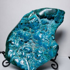 May include: A large, irregularly shaped piece of blue and green chrysocolla with a smooth, polished surface. The stone has a unique, marbled pattern with a variety of shades of blue and green.
