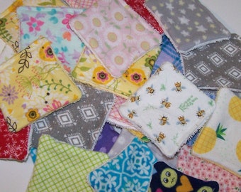 May include: A selection of colourful, square fabric items with diverse patterns. Designs include flowers, bees, geometric shapes, and pineapples. The fabrics are in shades of yellow, pink, grey, and blue.