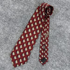 May include: A necktie featuring a deep red background with a repeating grid pattern of dark gray squares containing small, light-colored, curved leaf-like motifs. The tie includes a label reading J.Z. RICHARDS and a black fabric keeper loop.
