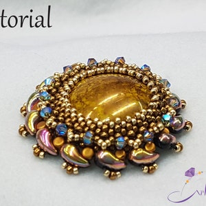May include: A gold and brown beaded brooch with a large, round, brown gemstone in the center. The brooch is surrounded by smaller, iridescent beads in shades of purple, blue, and gold.