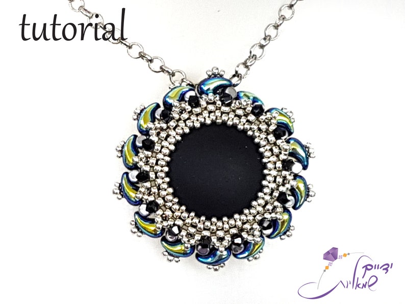 May include: A silver chain necklace with a black and silver beaded pendant. The pendant features a circular design with a black center and a border of silver and iridescent blue and green beads.