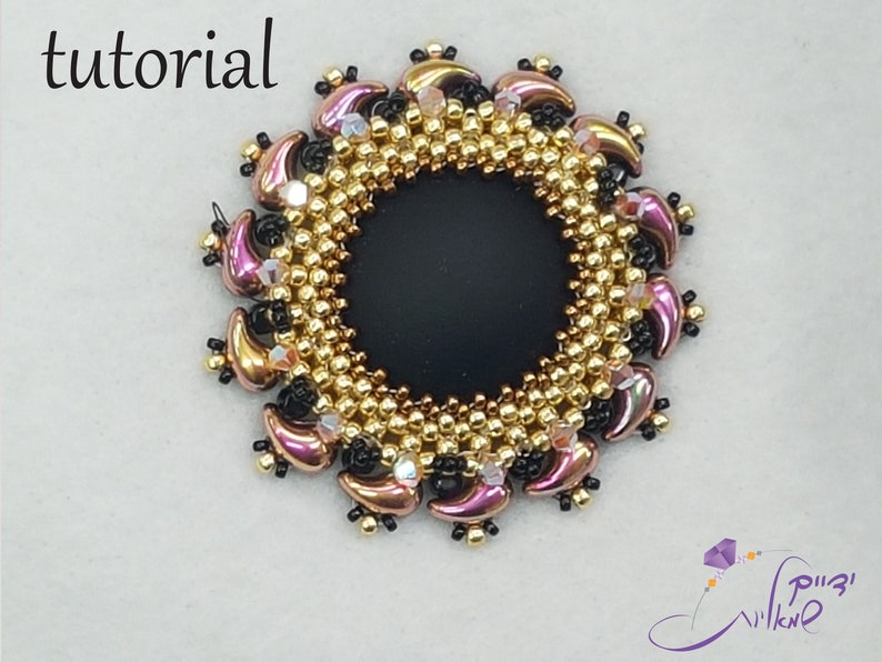 May include: A close-up of a beaded jewelry piece with a black center and a gold and pink beaded border. The piece is circular and has a delicate, intricate design.