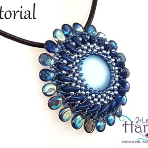 Pode incluir: Um pingente de contas azuis e prateadas com um centro azul claro, pendurado em um cordão preto. O pingente tem a forma de uma flor com um centro circular. O texto "2 Left Hands" é visível no canto inferior direito da imagem.