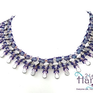 May include: A silver and purple beaded necklace with a teardrop design. The necklace is made with various sizes and shapes of beads, including silver, purple, and blue.