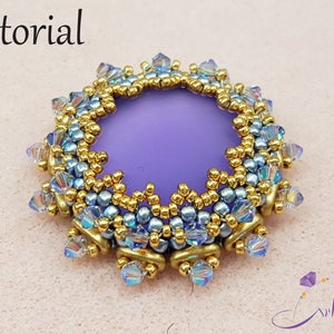 May include: A beaded craft project with a central purple element, surrounded by gold and blue beads. The word "tutorial" is written at the top. The design features a circular shape with intricate details, showcasing a handmade craft.