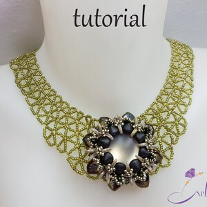 May include: A green beaded necklace with a large, black and silver flower pendant. The pendant has a large, iridescent, gray center stone.