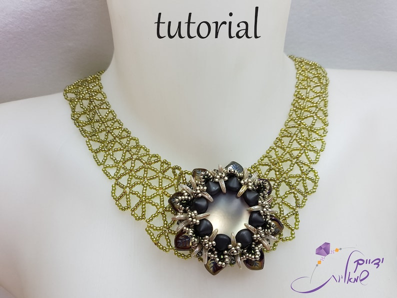 May include: A green beaded necklace with a large, black and silver flower pendant. The pendant has a large, iridescent, gray center stone.