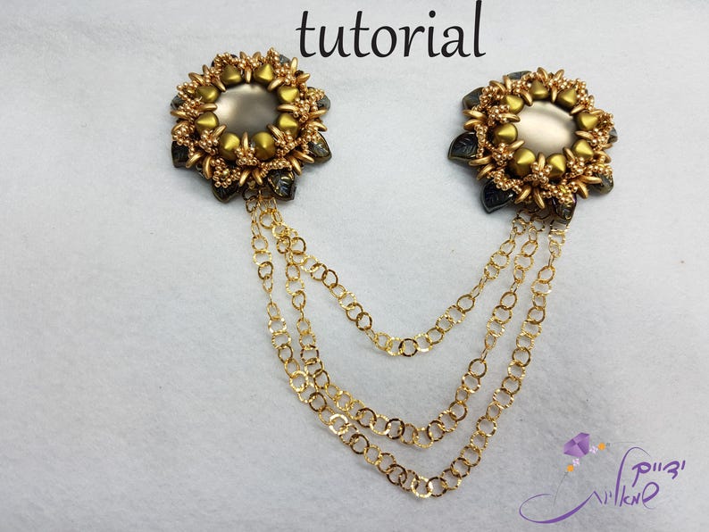 May include: Two gold and gray beaded flower brooches with a chain attached to each. The brooches are connected by a long gold chain.