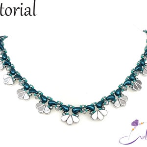 Pode incluir: Um colar de contas turquesa e prata com um design floral. O colar é feito com contas pequenas em forma de lágrima e contas maiores em forma de flor.