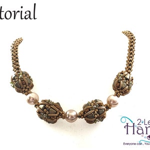 Könnte beinhalten: Eine goldene Perlenkette mit vier großen, braunen Perlenkugeln und drei rosafarbenen Perlen. Die Kette liegt auf weißem Hintergrund. Der Text "2 Left Hands" ist in der unteren rechten Ecke des Bildes zu sehen.