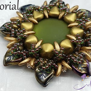 May include: A gold and green beaded flower brooch with a green center. The brooch is made with small beads and has a starburst shape.