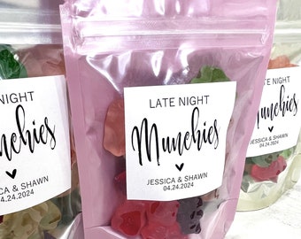 May include: Pink cellophane bags filled with colorful gummy bears. Each bag has a white label with the words "LATE NIGHT Munchies" and the names "JESSICA & SHAWN" with the date "04.24.2024".