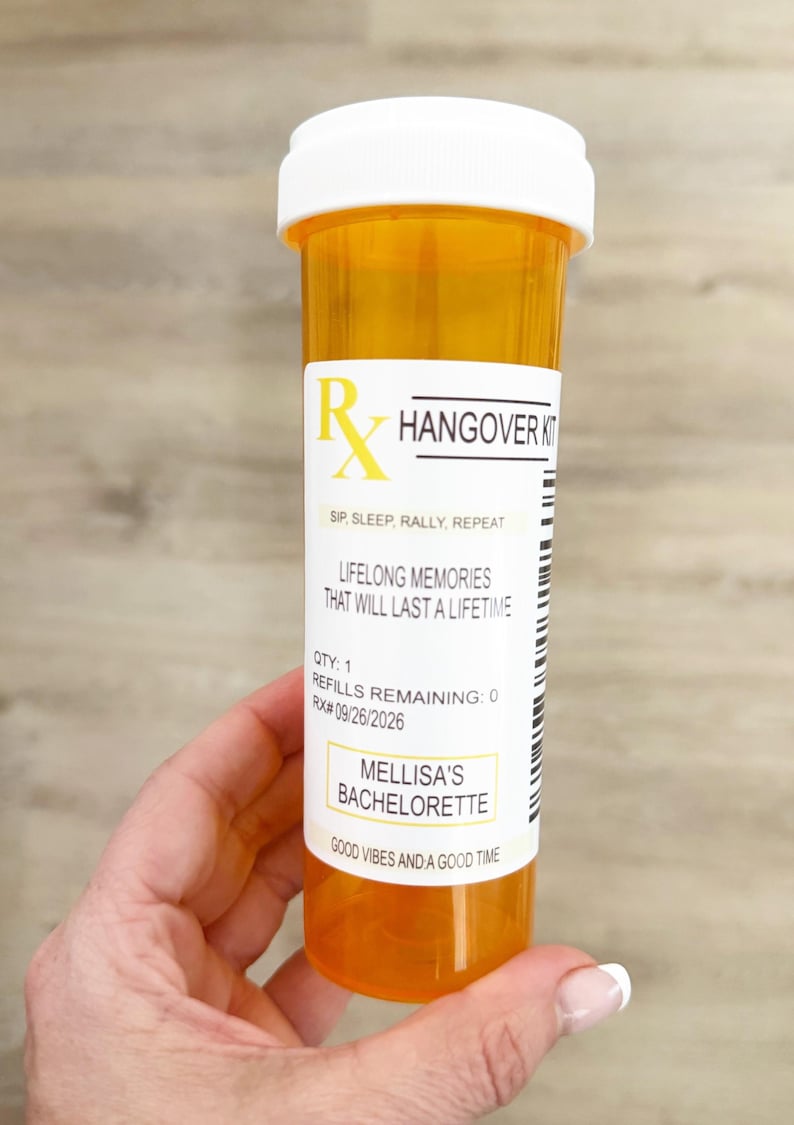 Może przedstawiać: Pomarańczowa butelka po leku z białą pokrywką, z napisem "Hangover Kit". Etykieta zawiera tekst "Lifelong Memories That Will Last a Lifetime" i "Mellisa's Bachelorette."