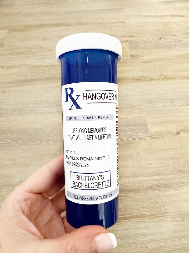 Może przedstawiać: Niebieska butelka na receptę z białą pokrywką, z napisem "Hangover Kit". Etykieta zawiera tekst "Sip, Sleep, Rally, Repeat", "Lifelong Memories" i "Brittany's Bachelorette". Butelka jest trzymana przez osobę.