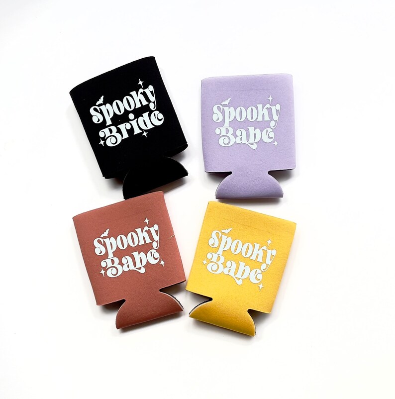 May include: Four different colored can coolers with the text "Spooky Babe" or "Spooky Bride" in white lettering.