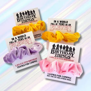 May include: Four scrunchies in yellow, lavender, and pink, each paired with a card. The cards feature the text "Birthday Things" and "In a World Full of Tens Be an Eleven". The scrunchies are for a 13th birthday.