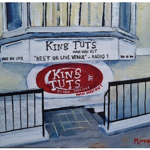 May include: An acrylic painting of King Tut's Wah Wah Hut in Glasgow, Scotland. The sign reads "Best UK Live Venue - Radio 1". The building is painted in white, blue, and yellow, with a red oval sign. The painting includes the artist's signature.