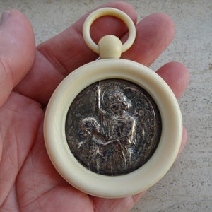 Religious antique French catholic bakelite Art Deco cradle medal medallion pendant of cherub Guardian Angel Raphael protecting a baby. K 28