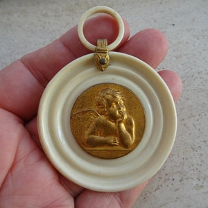 Religious antique French catholic bakelite Art Deco cradle medal charm medallion pendant of a cherub Guardian Angel Raphael. K 29