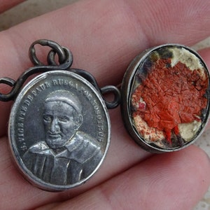 Medalla relicario francesa antigua, religiosa, plateada, con colgante de santuario y paño interior de San Vicente de Paúl. (G 1)