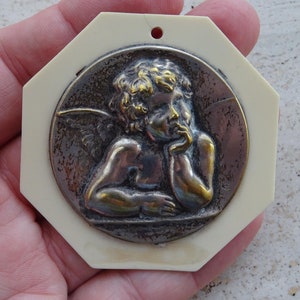Religious antique French catholic bakelite Art Deco cradle medal charm medallion pendant of a cherub Guardian Angel Raphael. K 45