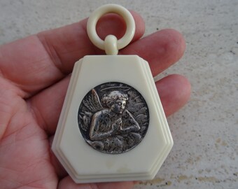 Religious antique French catholic bakelite Art Deco cradle medal charm medallion pendant of a praying cherub Guardian Angel Raphael. K 54