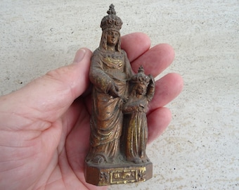 May include: A gold-toned metal statue of the Virgin Mary and child. The statue is about 6 inches tall and is in a standing position. The Virgin Mary is wearing a crown and a long robe. The child is wearing a crown and a short robe. The statue is on a small base.