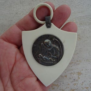 Religious antique French catholic bakelite Art Deco cradle medal medallion pendant of cherub Guardian Angel Raphael protecting a baby. K 17