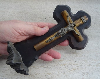 Puede incluir: Un crucifijo de madera con una figura de Jesús de metal. El crucifijo es de color marrón oscuro y tiene un acabado desgastado. La figura de Jesús es de plata y tiene una corona de espinas.