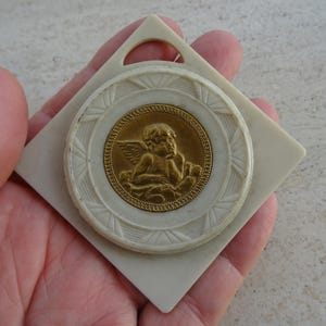 Religious antique French catholic bakelite Art Deco cradle medal charm medallion pendant of a cherub Guardian Angel Raphael. K 35
